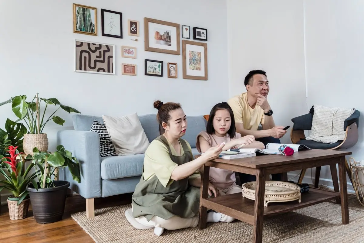 Cả nhà cùng đọc sách bên bàn trà trong phòng khách