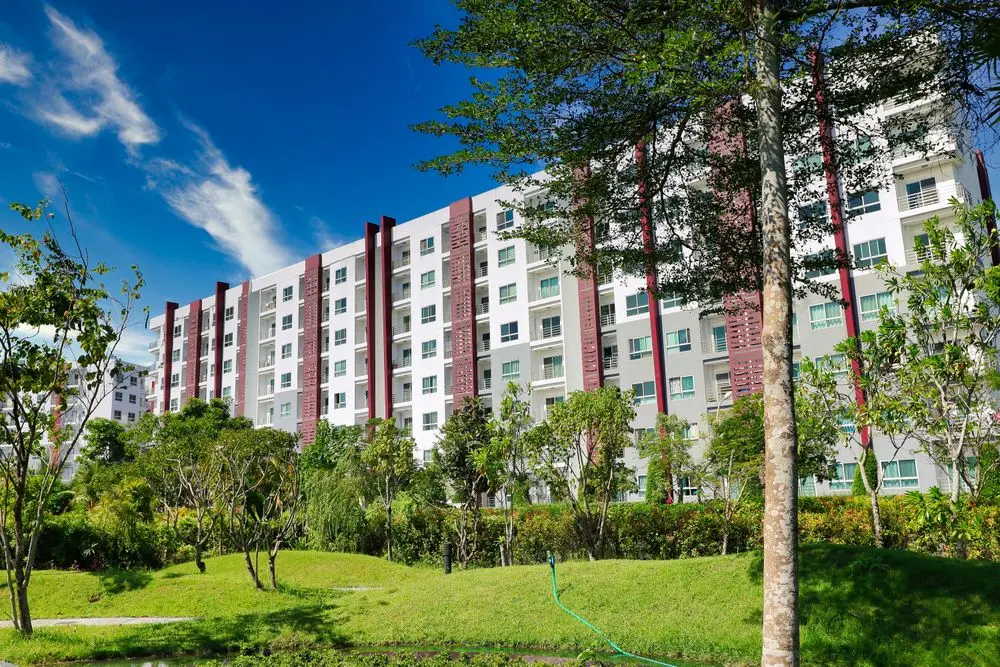 Tòa nhà ở nhiều tầng giữa hàng cây và bãi cỏ